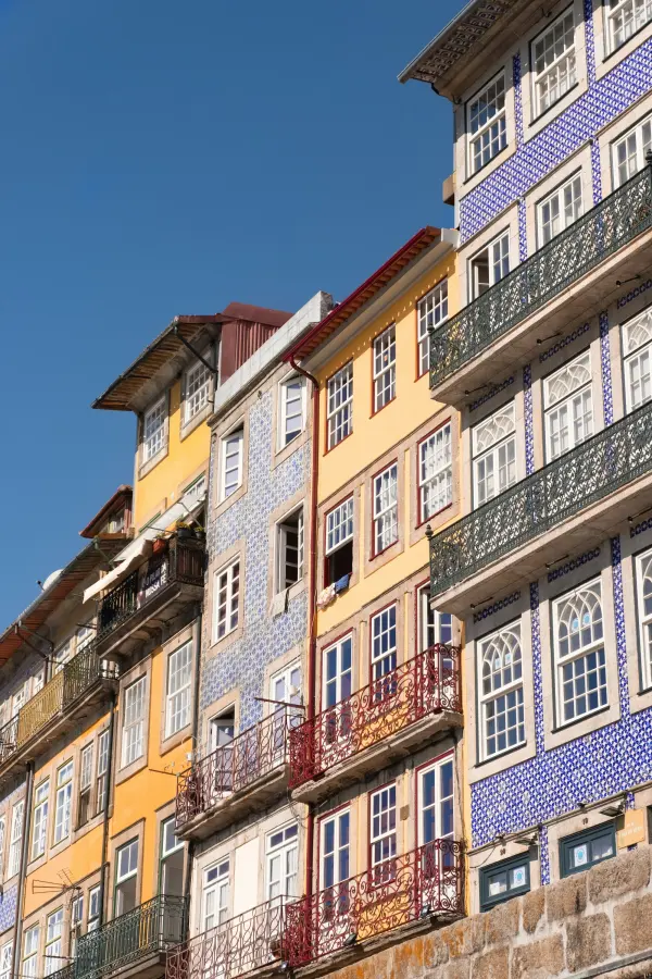 Fachadas estreitas da Ribeira do Porto, com azulejo azul e varandas de ferro.